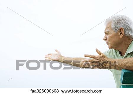 Senior man sitting with arms outstretched, looking away, side view View Large Photo Image Stock Photo - Senior man sitting with arms outstretched, looking away, side view. Fotosearch