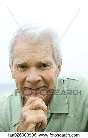 Senior man with hand under chin, smiling at camera, portrait View Large Photo Image Stock Photograph - Senior man with hand under chin, smiling at camera, portrait. Fotosearch