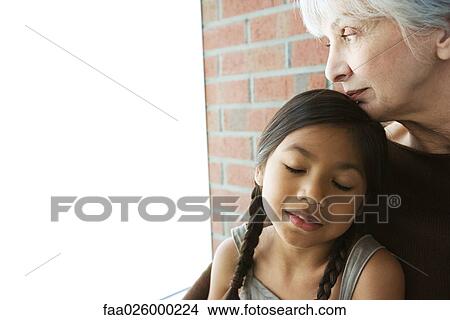 Senior woman resting her chin on granddaughter's head, girl's eyes closed View Large Photo Image Picture - Senior woman resting her chin on granddaughter's head, girl's eyes closed. Fotosearch