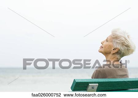 Senior woman sitting near sea, looking at view View Large Photo Image Stock Image - Senior woman sitting near sea, looking at view. Fotosearch