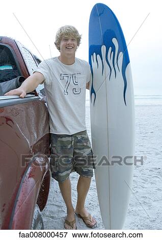 Surfer standing next to pick-up truck with surfboard View Large Photo Image Stock Photo - Surfer standing next to pick-up truck with surfboard. Fotosearch