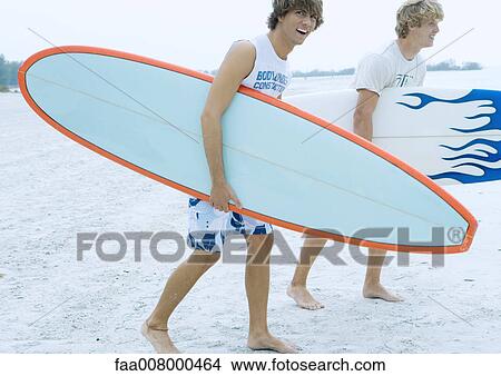 Surfers carrying surfboards View Large Photo Image Picture - Surfers carrying surfboards. Fotosearch