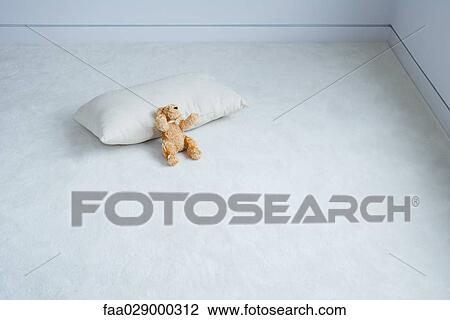 Teddy bear resting against cushion View Large Photo Image Stock Image - Teddy bear resting against cushion. Fotosearch