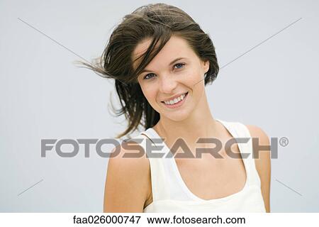 Teen girl, hair blowing in wind, smiling at camera, portrait View Large Photo Image Stock Photo - Teen girl, hair blowing in wind, smiling at camera, portrait. Fotosearch