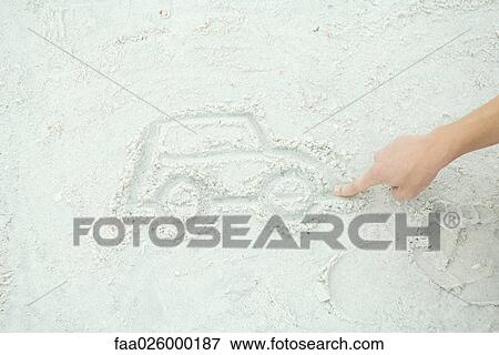Stock Photo - Teenage boy drawing car in sand, cropped view. Fotosearch