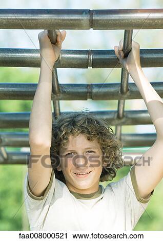 Teenage boy hanging from bars View Large Photo Image Stock Image - Teenage boy hanging from bars. Fotosearch