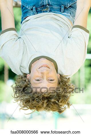 Teenage boy hanging upside down View Large Photo Image Stock Photograph - Teenage boy hanging upside down. Fotosearch