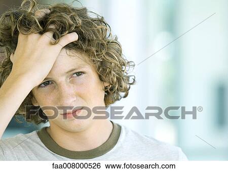 Teenage boy holding head View Large Photo Image Stock Photograph - Teenage boy holding head. Fotosearch