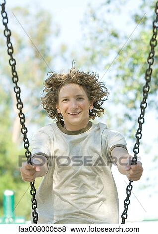 Teenage boy on swing View Large Photo Image Stock Photo - Teenage boy on swing. Fotosearch