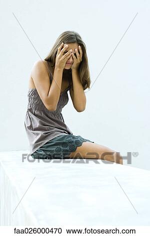 Teenage girl covering eyes with hands, peeking through fingers at camera View Large Photo Image Stock Image - Teenage girl covering eyes with hands, peeking through fingers at camera. Fotosearch