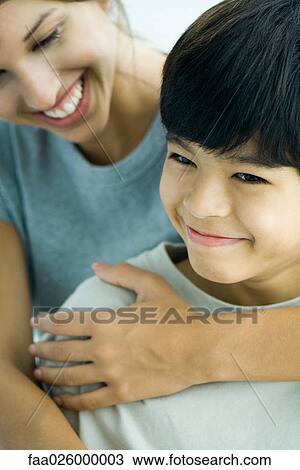 Teenage girl embracing boy, both smiling, cropped view View Large Photo Image Stock Image - Teenage girl embracing boy, both smiling, cropped view. Fotosearch