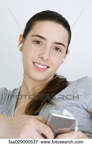 Teenage girl listening to MP3 player, smiling at camera View Large Photo Image Stock Photo - Teenage girl listening to MP3 player, smiling at camera. Fotosearch