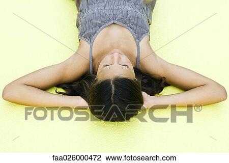 Teenage girl lying on back with hands under head, eyes closed, high angle view View Large Photo Image Stock Image - Teenage girl lying on back with hands under head, eyes closed, high angle view. Fotosearch