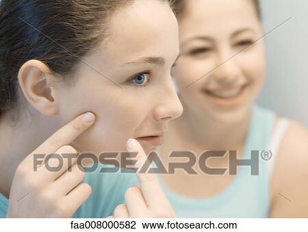 Teenage girl touching face while friend watches View Large Photo Image Stock Image - Teenage girl touching face while friend watches. Fotosearch