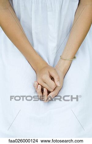 Picture - Teenage girl with clasped hands, cropped view. Fotosearch