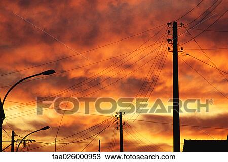 Telephone lines and street lights at sunset, silhouette, low angle view View Large Photo Image Stock Image - Telephone lines and street lights at sunset, silhouette, low angle view. Fotosearch