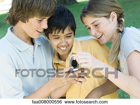 Three preteen friends looking at cell phone View Large Photo Image Stock Photograph - Three preteen friends looking at cell phone. Fotosearch