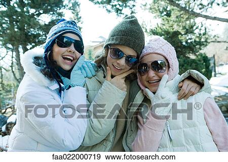 Three teen girls wearing winter clothes and sunglasses, holding chins, laughing View Large Photo Image Stock Photo - Three teen girls wearing winter clothes and sunglasses, holding chins, laughing. Fotosearch
