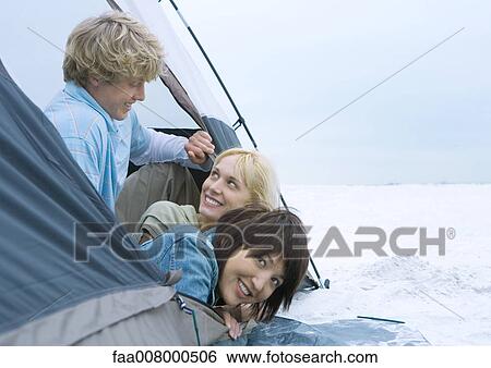 Three young adult friends looking out of tent View Large Photo Image Stock Photograph - Three young adult friends looking out of tent. Fotosearch