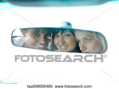 Three young women, faces reflected in rearview mirror View Large Photo Image Stock Photography - Three young women, faces reflected in rearview mirror. Fotosearch
