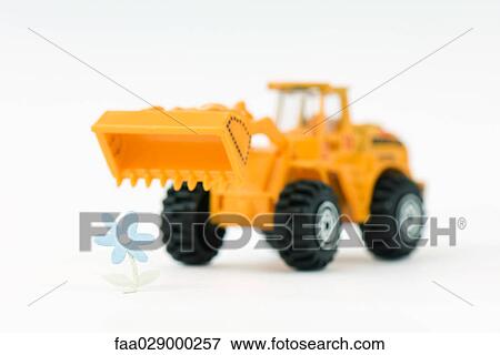Toy bulldozer approaching flower View Large Photo Image Stock Photo - Toy bulldozer approaching flower. Fotosearch