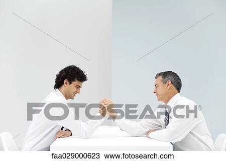 Two businessmen arm wrestling, eyes closed, side view View Large Photo Image Stock Image - Two businessmen arm wrestling, eyes closed, side view. Fotosearch