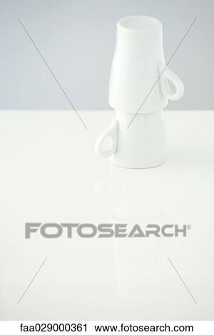 Stock Image - Two coffee mugs stacked, one on top of the other. Fotosearch