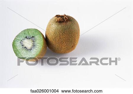 Two kiwis, one cut, the other whole, close-up View Large Photo Image Picture - Two kiwis, one cut, the other whole, close-up. Fotosearch