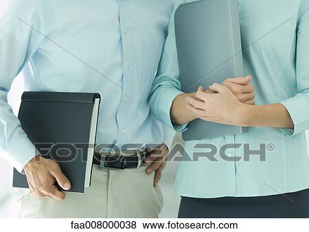 Two office workers, mid section View Large Photo Image Stock Photo - Two office workers, mid section. Fotosearch