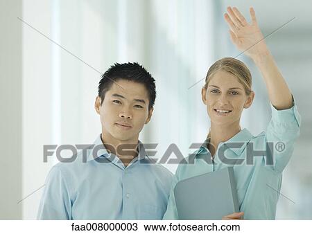 Stock Image - Two office workers, one waving. Fotosearch