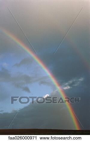 Two rainbows and cloudy sky over rural field View Large Photo Image Stock Image - Two rainbows and cloudy sky over rural field. Fotosearch
