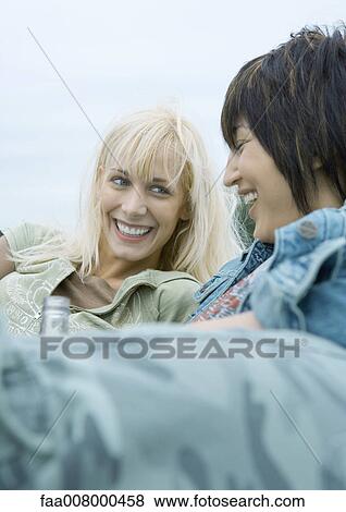 Two young women reclining and laughing View Large Photo Image Stock Photo - Two young women reclining and laughing. Fotosearch