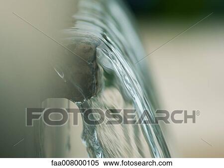 Stock Photography - Water flowing over edge, extreme close-up. Fotosearch
