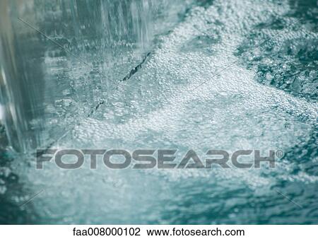 Stock Image - Waterfall in pool, close-up. Fotosearch