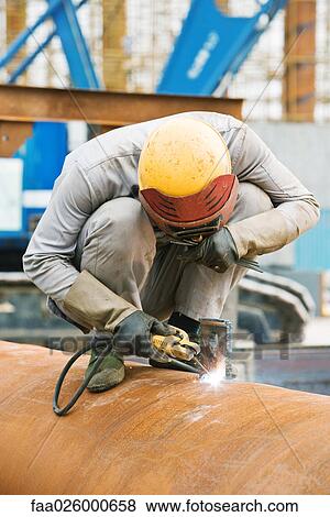 Welder crouching on metal pipe, head down View Large Photo Image Stock Photo - Welder crouching on metal pipe, head down. Fotosearch