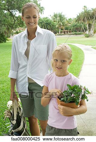 Woman and girl holding gardening supplies View Large Photo Image Stock Photography - Woman and girl holding gardening supplies. Fotosearch