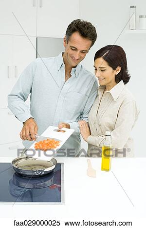 Stock Photography - Woman and man cooking in kitchen. Fotosearch