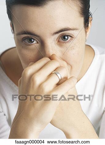 Woman covering mouth and nose with hands, portrait View Large Photo Image Picture - Woman covering mouth and nose with hands, portrait. Fotosearch