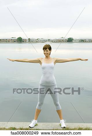 Stock Photo - Woman exercising, lakeside. Fotosearch