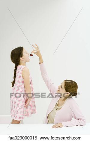 Woman feeding little girl cherries View Large Photo Image Stock Photography - Woman feeding little girl cherries. Fotosearch