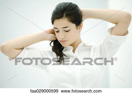 Woman fixing hair, holding hairpin in mouth, looking down View Large Photo Image Stock Photo - Woman fixing hair, holding hairpin in mouth, looking down. Fotosearch