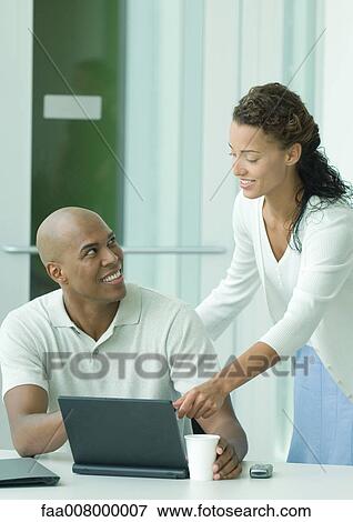 Stock Photo - Woman helping male colleague. Fotosearch