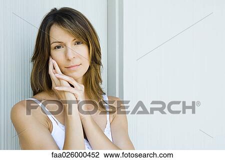 Woman holding face, looking at camera View Large Photo Image Stock Image - Woman holding face, looking at camera. Fotosearch