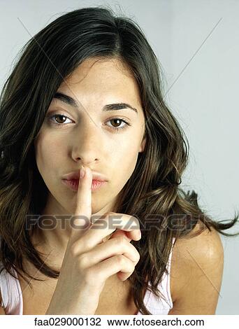 Woman holding finger on lips, looking at camera, portrait View Large Photo Image Stock Image - Woman holding finger on lips, looking at camera, portrait. Fotosearch