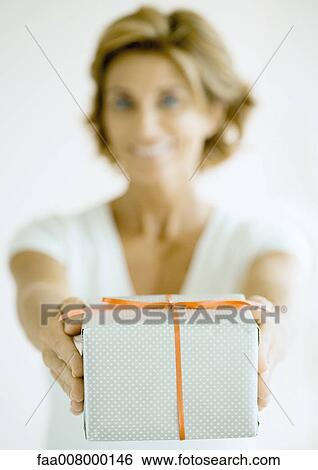 Woman holding out present View Large Photo Image Stock Photograph - Woman holding out present. Fotosearch