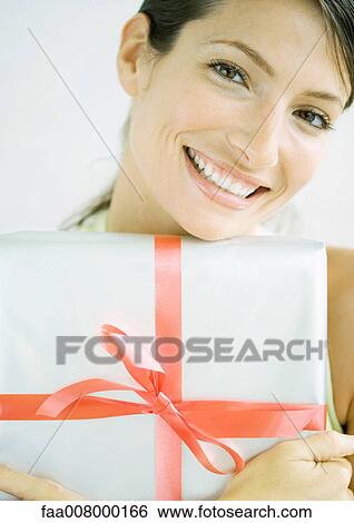 Stock Photograph - Woman holding present in arms. Fotosearch