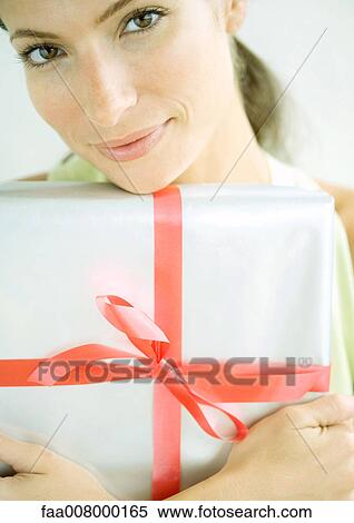 Woman holding present in arms View Large Photo Image Stock Photography - Woman holding present in arms. Fotosearch