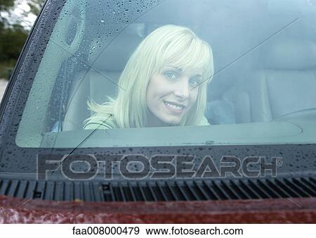 Stock Photo - Woman in car, seen through windshield. Fotosearch