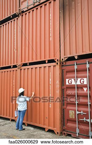 Woman in hard hat writing on metal storage unit, rear view View Large Photo Image Stock Photo - Woman in hard hat writing on metal storage unit, rear view. Fotosearch
