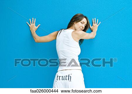 Woman in pants with the word "truth" on backside, standing with hands against wall, looking over shoulder at camera View Large Photo Image Picture - Woman in pants with the word "truth" on backside, standing with hands against wall, looking over shoulder at camera. Fotosearch